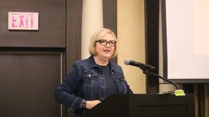 A woman speaks at a podium