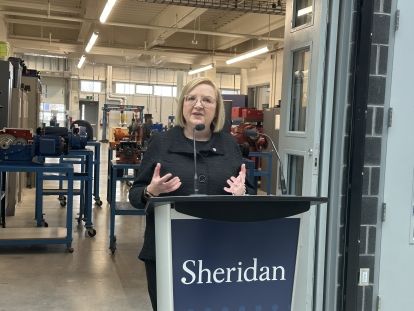 Lana Payne standing at podium at Sheridan College
