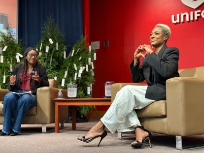 Two women sitting on stage infront a red Unifor screen