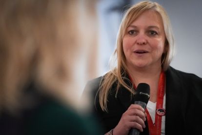 Jenn Murray speaking into a mic