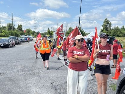 People wearing red respect teeshirts walking on street with red flags
