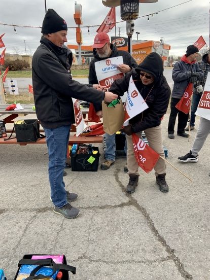 A volunteer hands out gift bags to striking workers
