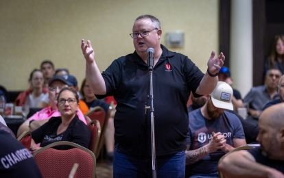 Man standing in meeting room with arms raised