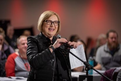 Lana Payne speaking at a floor microphone