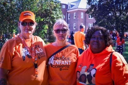 Three people wearing orange shirts