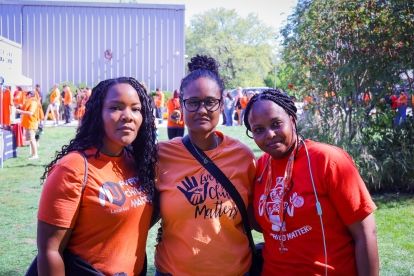 Three people in orange shirts