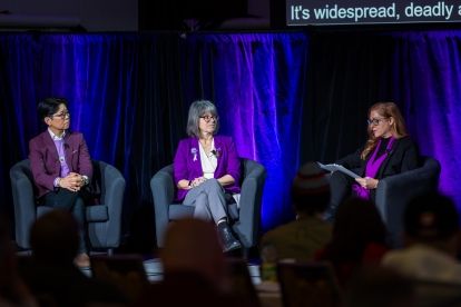 Three women sitting in bucket chairs on a pannel talking