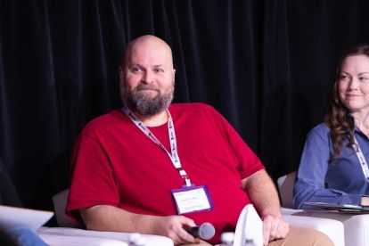 A man sitting holding a mic