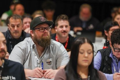 Un groupe de personnes assises à des tables tournées vers l'avant