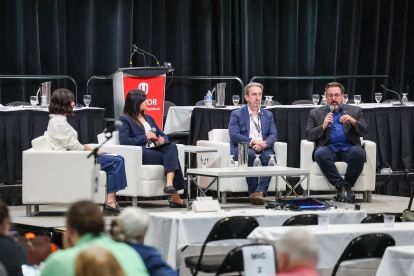 Quatre personnes assises sur une scène, sur des chaises blanches