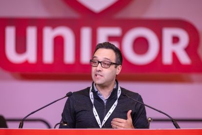 Angelo DiCaro speaks at a podium.