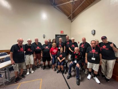 A large group of people together smiling.