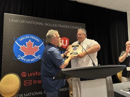 Two men holding an award