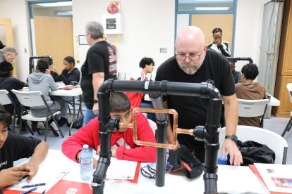 A man teaching a student on a hands on structure