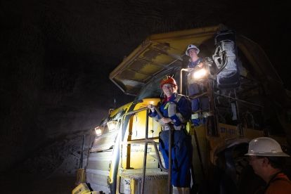 Two people in a dark mine with a light