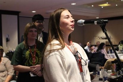 a women speaks at a mic