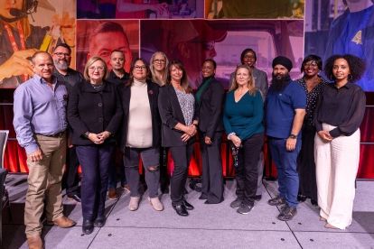 A goup of people stanidng in front a backdrop college