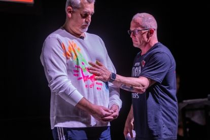 Two men standing facing one has his hand on the other.