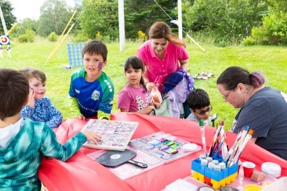 Children doing crafts at a picnic table