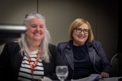 Deux femmes souriantes avec un verre d'eau sur la table