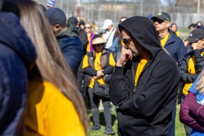 A group with their heads lowered in emotion