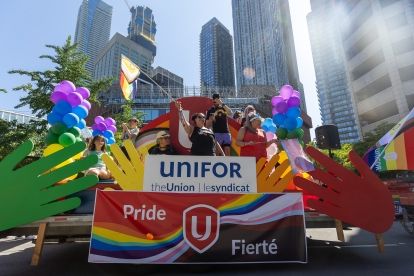 People waving on the Unifor Pride float