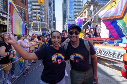 Two people in a parade smiling