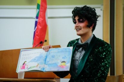Cyril Cinder an Ottawa-based drag king holding up a childrens story book