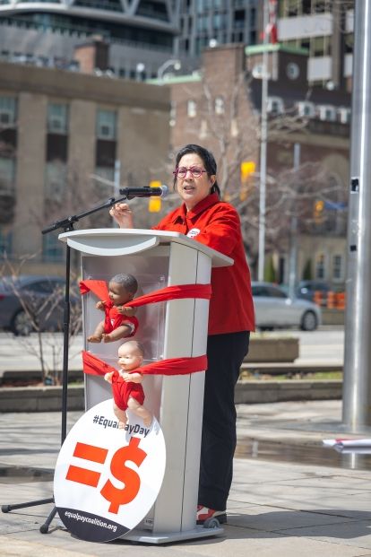 A women speaking at an outdoor podium
