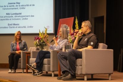 a pannel of four people sitting on stage in chairs