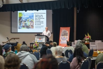 A women speaking at a podium with a screen presentation