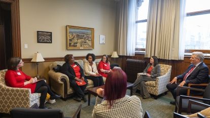 Women sitting around a boardroom table.