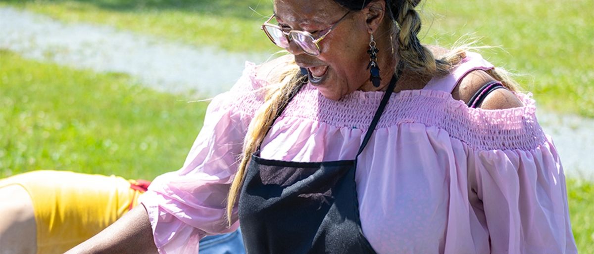 A women wearing an apron outside barbequing 