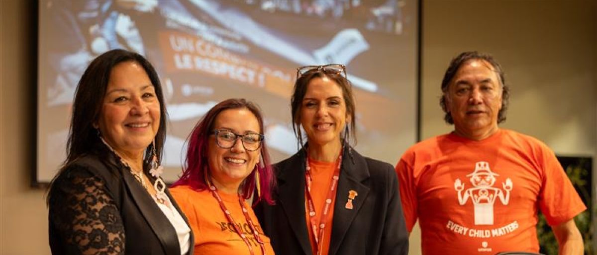 Four people wearing orange shirts