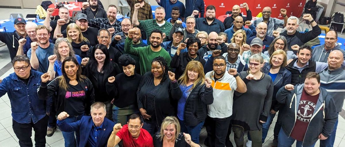 Large group posing with fists in the air