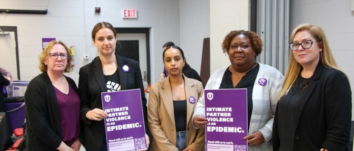 Four women holding up IPV signs, purple with white