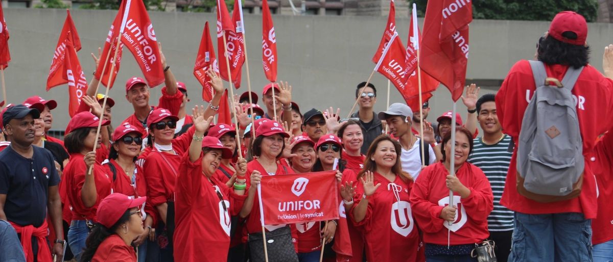 Unifor members celebrate Labour Day, wearing Unifor jerseys and carrying flags