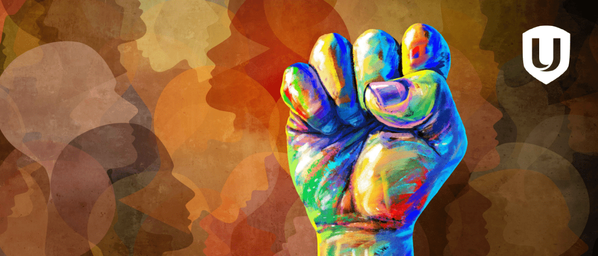 An artistic backgroud of profiles and a splotted coloured fist raised.