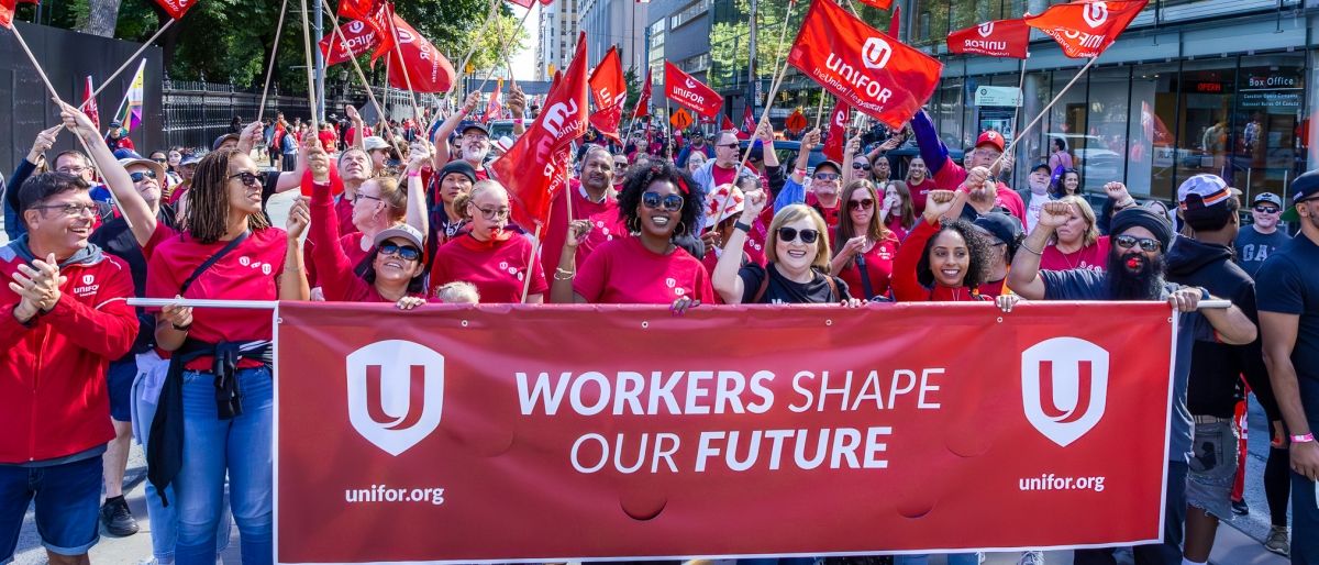 Labour Day parade march a crowd behind a banner
