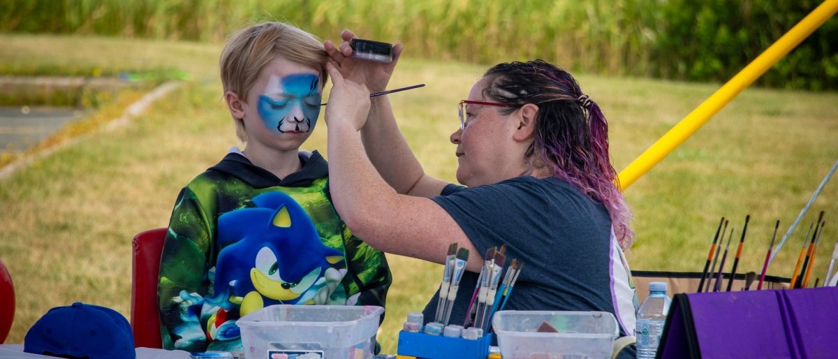 A women painting a childs face