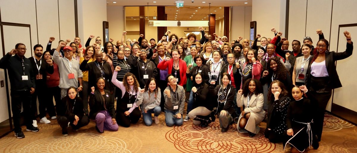A large group of people posing fists raised 