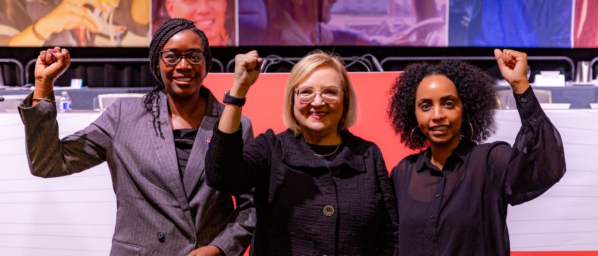 Three womens with their fists in the air.