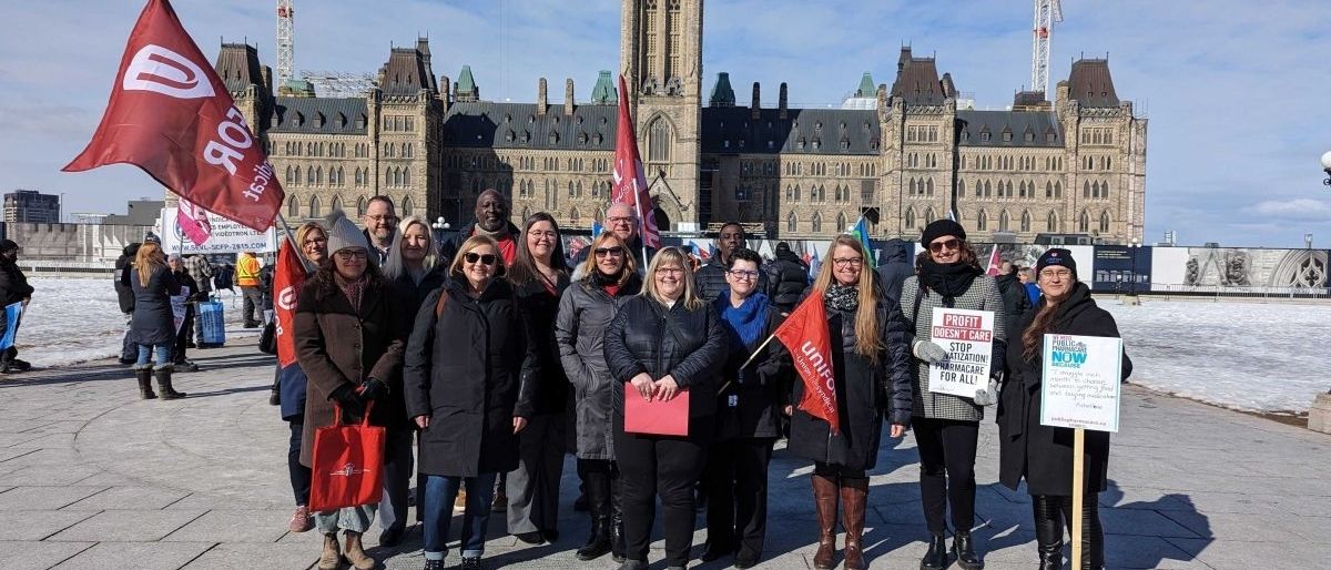 Crowd of Unifor members and allies gathered at a public health care rally on Parliament Hill, holding signs in support of publicly funded health care.