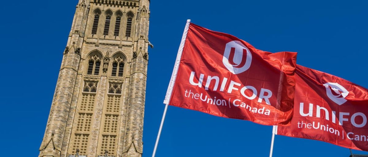 Two Unifor flags fly in front of the Peace Tower on Parliament Hill in Ottawa.