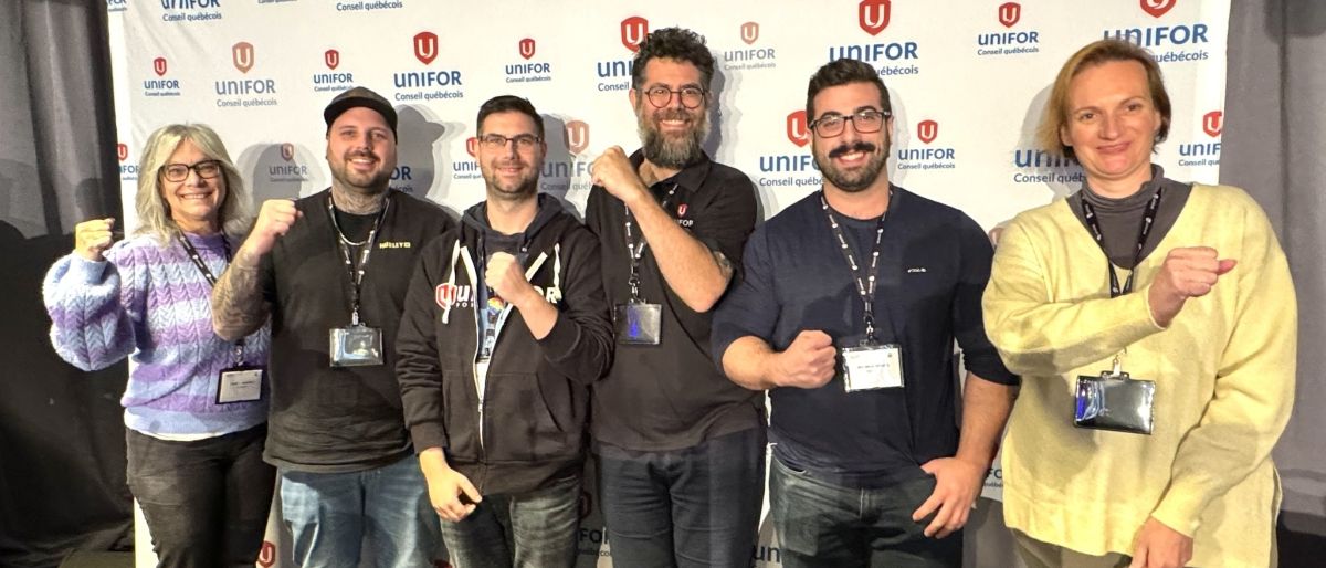 Six people posing in front of a banner