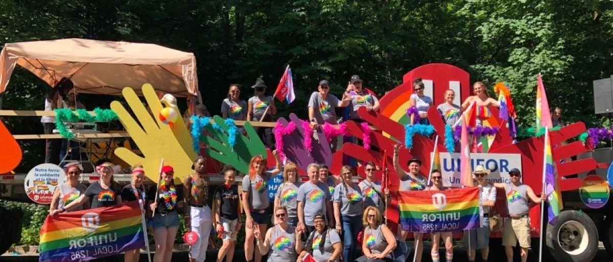 Unifor at Toronto pride a group standing in front of a prade float