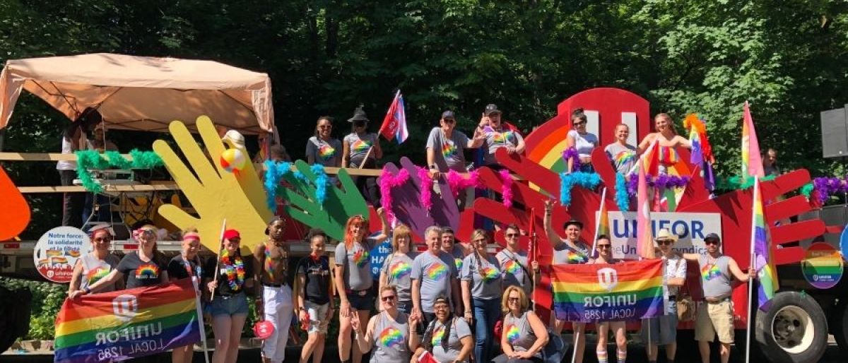 Unifor at Toronto pride a group standing in front of a prade float 