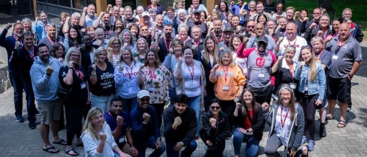A large group pose outside