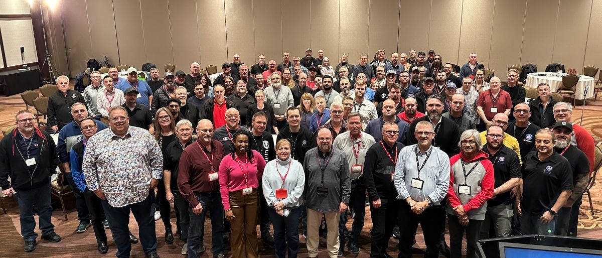 A large group of people standing in a conference room