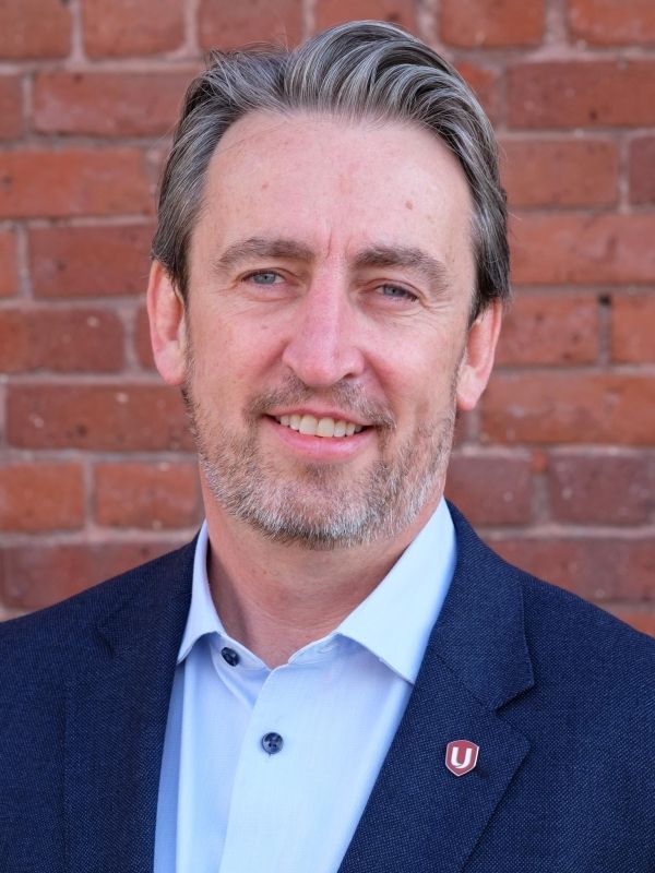 Gavin McGarrigle standing in front of a red brick wall